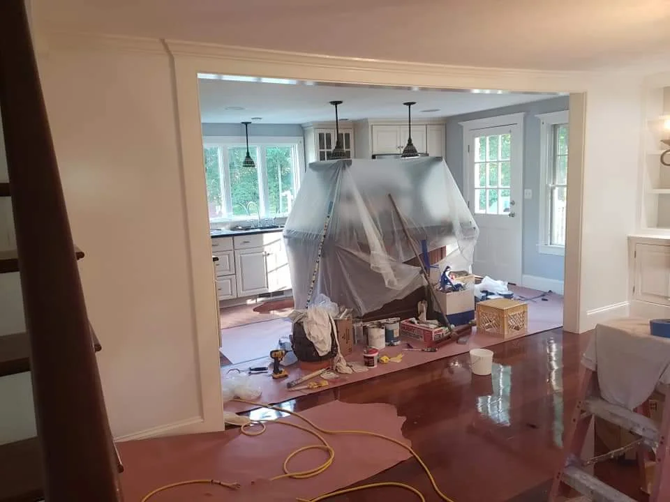 T&B Paint Pros LLC kitchen repaint completed. Fresh soft blue paint on walls, protective coverings still in place. Flagler County kitchen makeover, professional interior painting, home transformation.