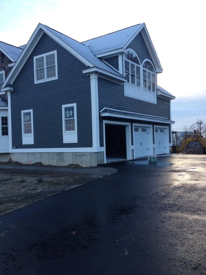 Beautifully painted garage and side exterior of a two-story home in Walpole, MA, featuring dark blue siding with white trim, professionally completed by T&B Paint Pros. tbpaintpros Flagler County Florida experienced painter, specializing in exterior painting and home transformations.