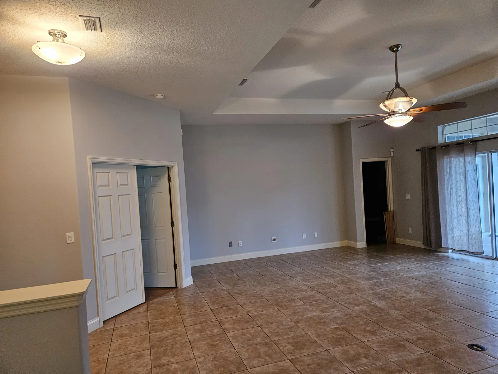T&B Paint Pros LLC interior painting – dining room and living room repaint in Ormond Beach, Volusia County, Florida. Featuring tray ceilings and fresh Sherwin Williams ‘Agreeable Gray’ paint, this home now feels bright, elegant, and modern. White trim enhances architectural details, transforming the space. Flagler County painter, professional painting company, house painters in Palm Coast, FL