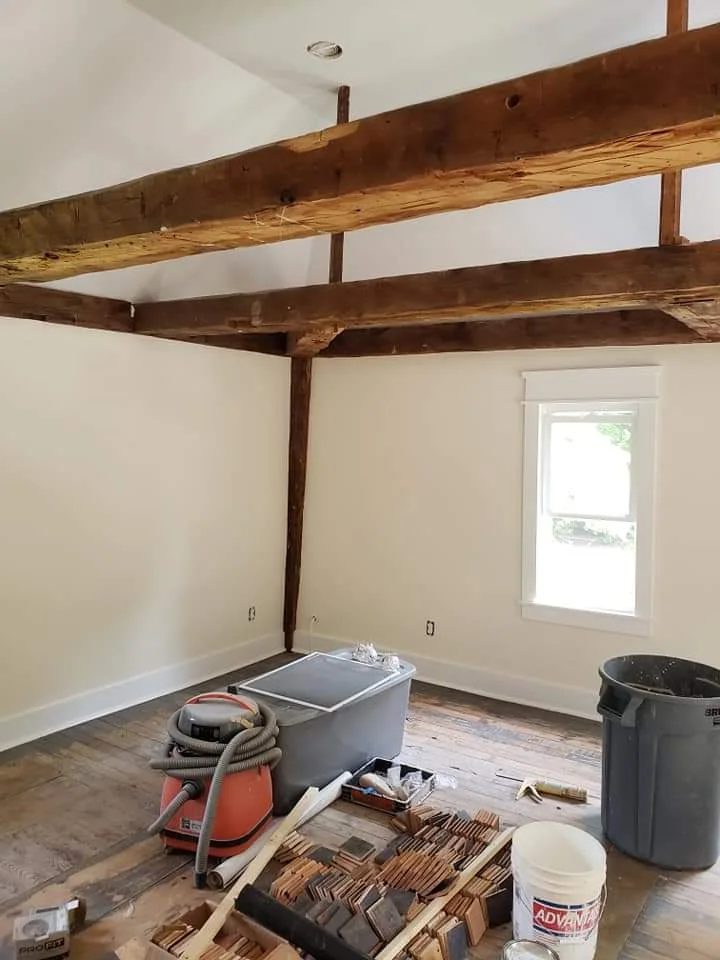 T&B Paint Pros LLC living room with white walls, vaulted ceilings, and historic post-and-beam design. Interior home painting and renovation showcasing craftsmanship in a stunning setting. Flagler County interior painter, home remodel.