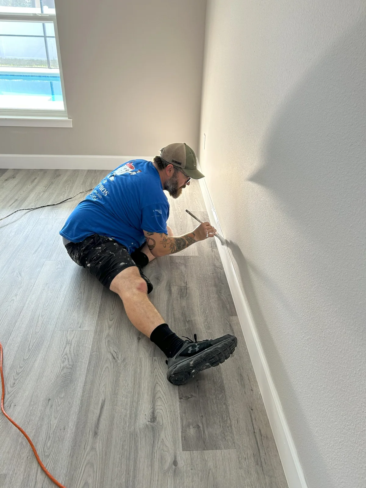 Beau from T&B Paint Pros LLC painting the trim in the primary bedroom of a Palm Coast FL home. His attention to detail and careful work ensure a high-quality finish in Sherwin Williams Popular Gray.