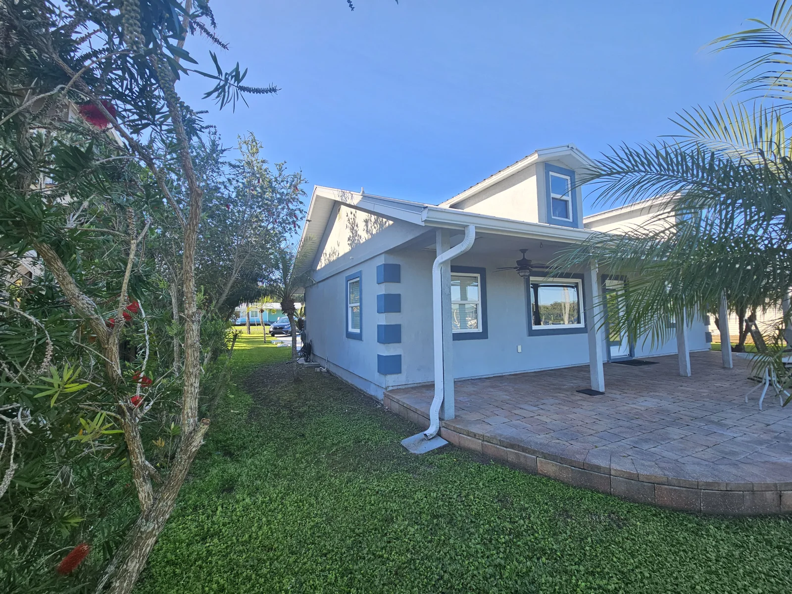 Exterior home painting in Welaka, FL – Freshly painted light blue stucco house with shed, after professional pressure washing, stucco repair, and repaint by T&B Paint Pros LLC, serving Palm Coast, St. Augustine, and Daytona Beach.