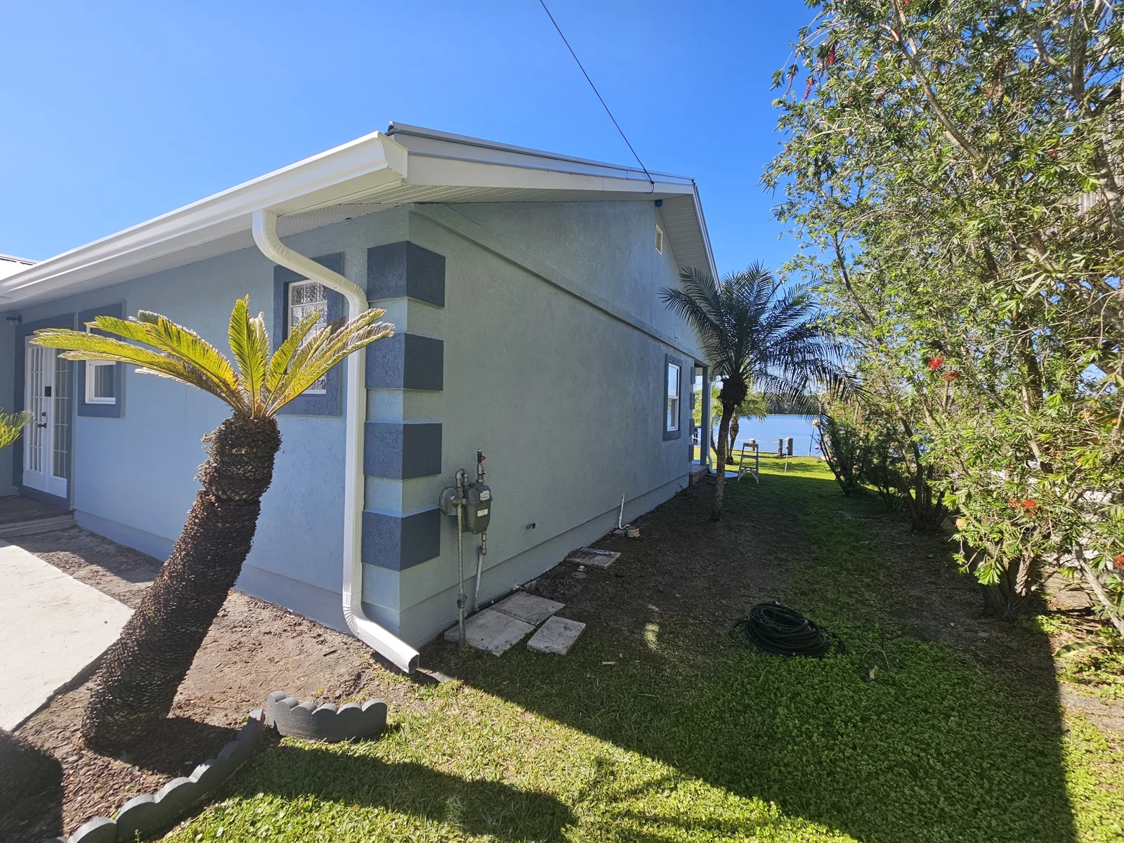A small glimpse of the water can be seen down the side of this riverfront home. A fresh coat of exterior paint and stucco repairs make this home shine! T&B Paint Pros LLC serving Palm Coast, St. Augustine, Daytona Beach FL, and the surrounding areas!