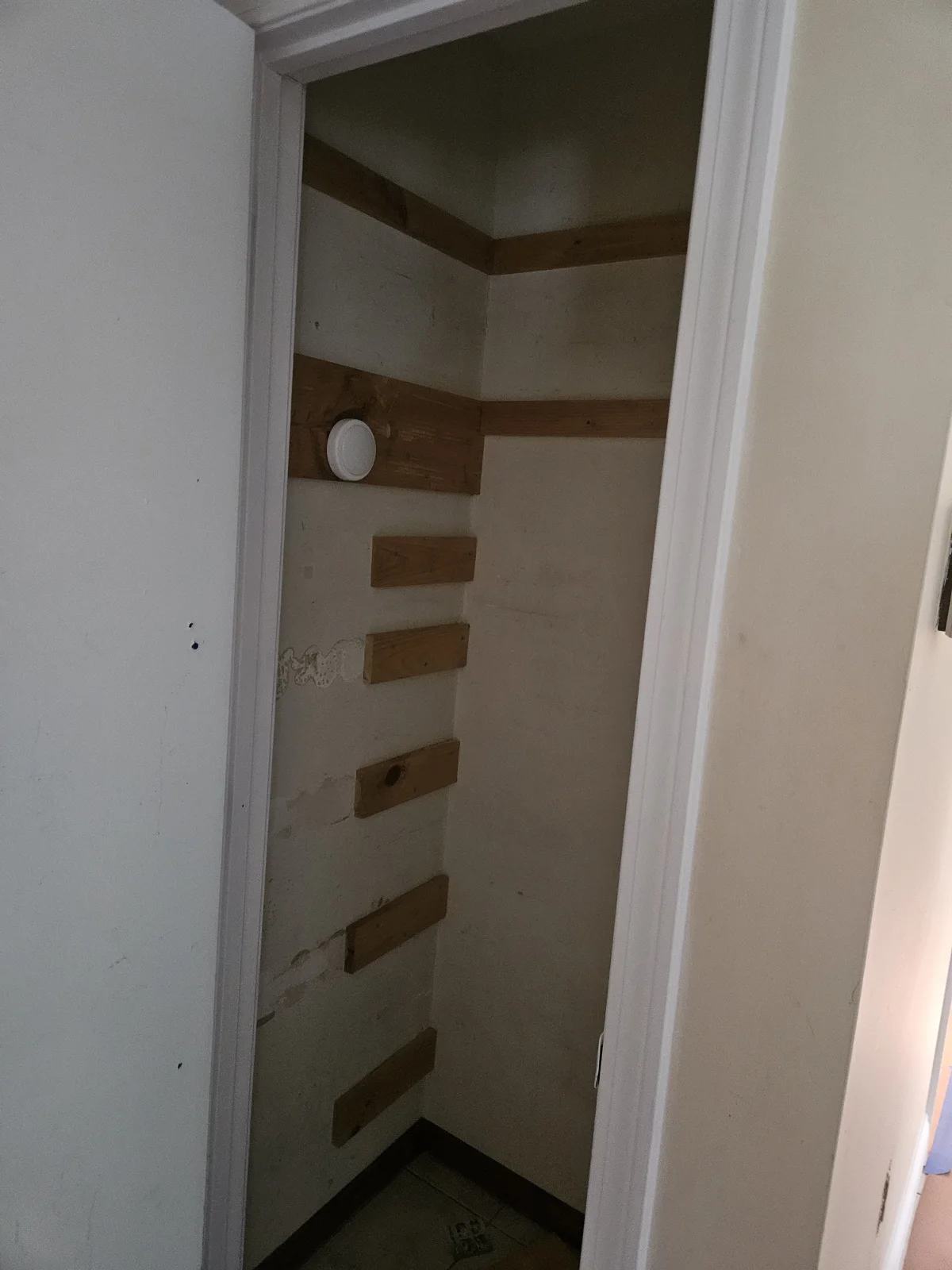 Closet with old white paint, unpainted shelf supports, and visible smoke detector before repainting. Closet Repaint by T&B Paint Pros, Flagler County Painter.