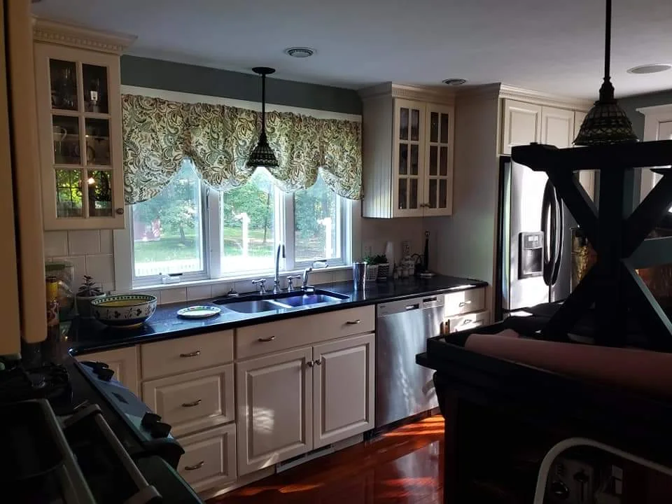 T&B Paint Pros LLC kitchen sink area with covered island after repaint. Meticulously protected surfaces, soft blue walls, Flagler County home interior painting.