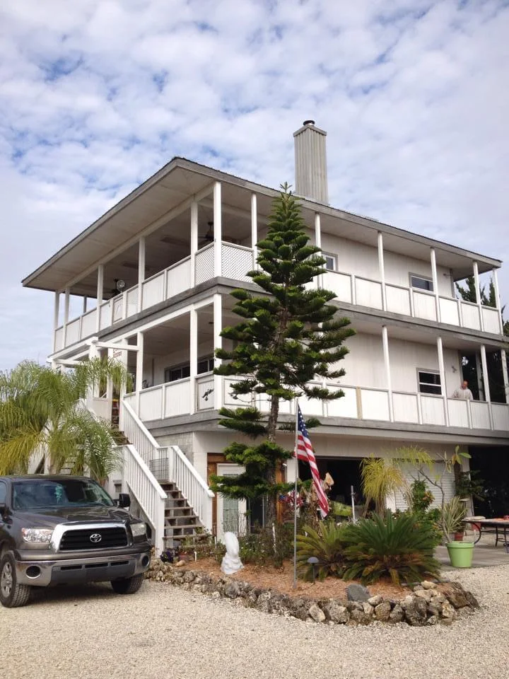 View of a coastal-style home in Crystal River, Florida, showing the freshly painted gray and white exterior with garage and gray accents, painted by T&B Paint Pros.