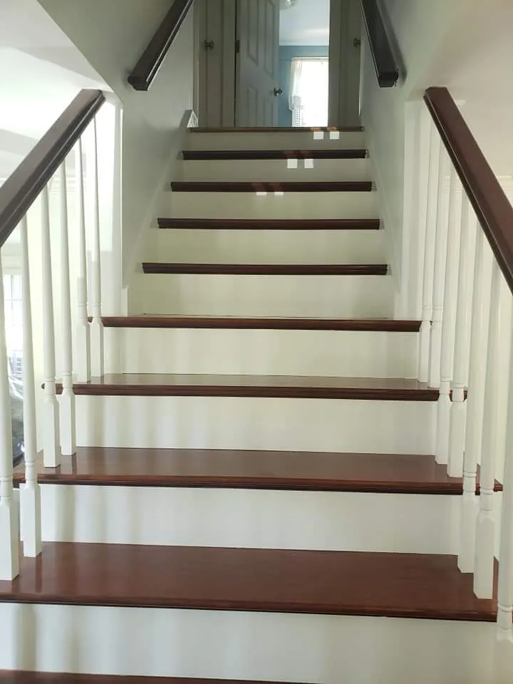 After: Stairwell with white-painted stairs and banister, freshly painted walls that brighten the space. Flagler County Painter, Residential Painting, Stairwell Makeover, T&B Paint Pros LLC.