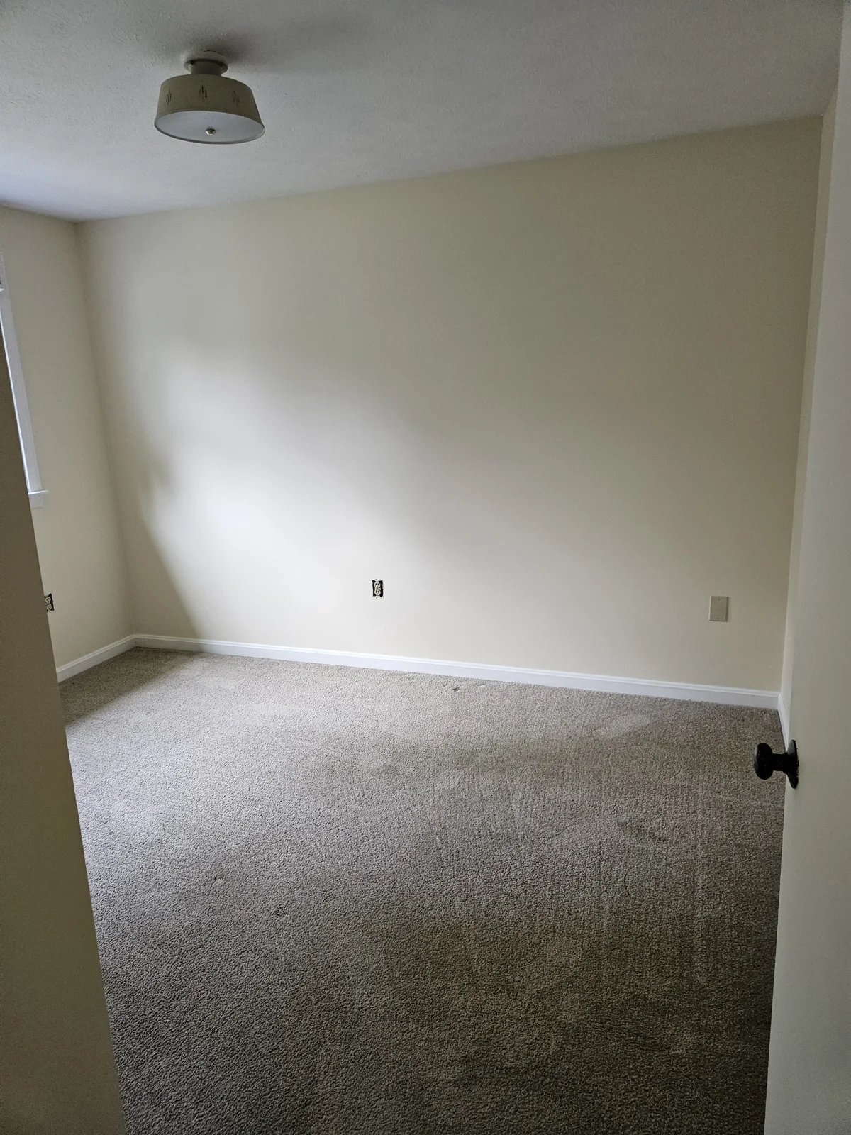 Soft yellow bedroom walls freshly painted by T&B Paint Pros. View from the door, showcasing the welcoming atmosphere and bright new paint job. Flagler County Painter, Residential Painting, Bedroom Makeover, T&B Paint Pros LLC.